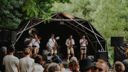 Konligo Fastival event structure with black membrane and outside backdrop hosting a brass band performance at an outdoor festival surrounded by trees, now available on MTN SHOP US. - imagen 13